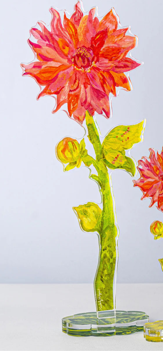 Transparent acrylic flower stand with pink and yellow flowers on a light gray background